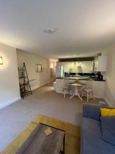 a living room with a couch and a table and a kitchen at Flat 1 Chestergate in Macclesfield