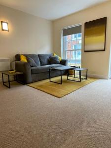 a living room with a couch and two tables at Flat 1 Chestergate in Macclesfield