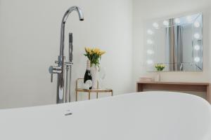 a white bathroom with a sink and a mirror at Cesare ai Cavalieri Suites in Rome