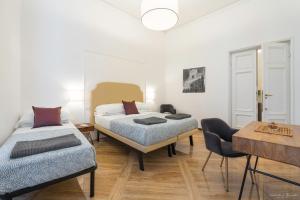 una camera con due letti e un tavolo di Vin Novo Rooms & Apartments a Firenze