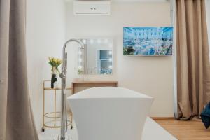 a bathroom with a white tub and a mirror at Cesare ai Cavalieri Suites in Rome