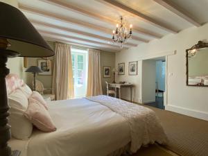 a bedroom with a large white bed with a chandelier at Clos de Bartinquie in Lalinde