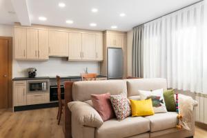 ein Wohnzimmer mit einem Sofa und bunten Kissen in der Unterkunft Asturalqui viviendas turísticas adaptadas in Llueves