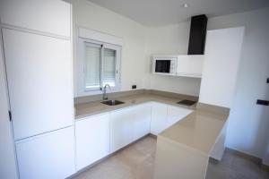 a white kitchen with a sink and a microwave at ON City Apartments in Matalascañas