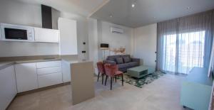 a kitchen and living room with a couch and a table at ON City Apartments in Matalascañas