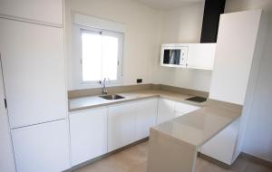 a white kitchen with a sink and a window at ON City Apartments in Matalascañas