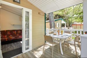 a patio with a table and chairs and a fireplace at Camping La Brande in Le Château-dʼOléron