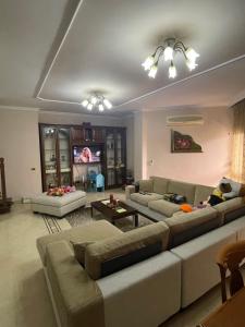 a living room with two couches and a tv at Luxury Center apartment in Tirana