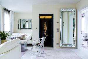a living room with a chair and a mirror at Hotel Palazzina Grassi in Venice
