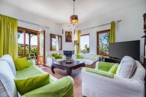a living room with white furniture and a flat screen tv at AURORA VILLA by K&K in Oia