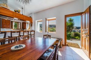 a kitchen and dining room with a wooden table and chairs at AURORA VILLA by K&K in Oia