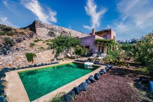 a house with a swimming pool in a yard at AURORA VILLA by K&K in Oia