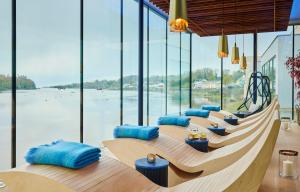 a row of tables with blue pillows in a room with windows at Ice House Hotel in Ballina