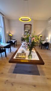 a room with a table with a vase of flowers at St-Georges IV in Ieper