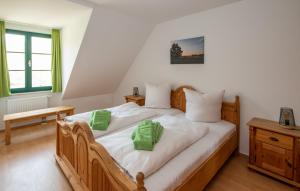 Un dormitorio con una cama de madera con almohadas verdes. en Spreewälder Feriendomizil/Pension, en Burg