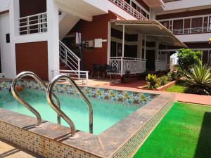 a swimming pool in front of a house at Redstone House by Oxystays Home Stay in Ganpatipule
