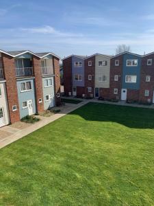 a row of apartment buildings with a green lawn at Beautiful 3 bed house in Hunstanton - near Searles with sea views in Hunstanton