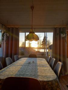 a dining room table with chairs and a large window at Mysig stuga i naturskönt område. in Vetlanda
