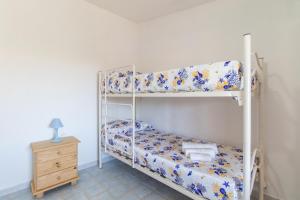 1 dormitorio con 2 literas y mesita de noche en Michelina en Capo Testa