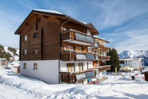 a large wooden building in the snow at Abusunna Penthouse in Riederalp