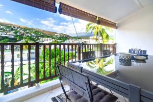 a balcony with a bench and a view of the ocean at Safari - Apt rénové proche des Roches Noires - Saint Gilles les Bains in Saint-Gilles-les-Bains