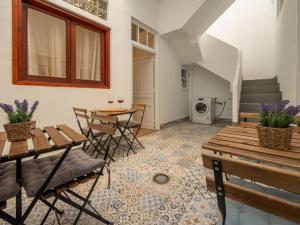 a living room with two tables and chairs and stairs at El Rincón de los Artistas in Las Palmas de Gran Canaria