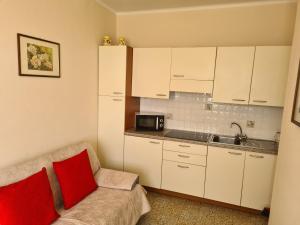 een kleine keuken met een bank en een magnetron bij La Casa di Aldo al Mare in Ospedaletti