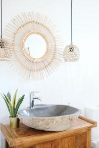 ein Badezimmer mit einem Steinwaschbecken und einem Spiegel in der Unterkunft Dreamsea Surf House Fuerteventura in Corralejo