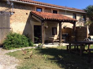 a house with a picnic table and a patio at Le Pressoir in Madiran