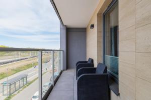 a balcony with chairs and a view of a highway at Apartament Przystań Letnica by Renters in Gdańsk