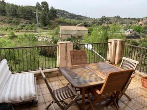 a wooden table and chairs on a balcony at Cal Roig in Margalef