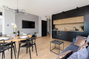 a living room and kitchen with a table and a couch at Apartament Przystań Letnica by Renters in Gdańsk