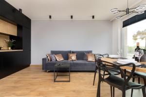 a living room with a blue couch and a table at Apartament Przystań Letnica by Renters in Gdańsk