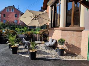 a patio with a table and an umbrella and chairs at Castel de Satoya in Belfort