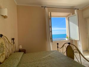 1 dormitorio con cama y ventana con vistas al océano en Hotel Le Najadi, en Santa Marinella