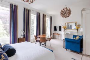 una camera con letto, tavolo e divano blu di 4 Berkeley Square I Your Apartment a Bristol