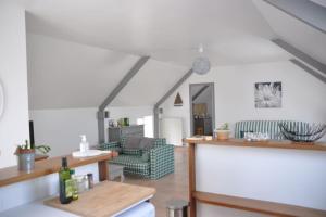 ein Wohnzimmer mit Sofa und Tisch in der Unterkunft Les Hortensias in Gatteville-le-Phare