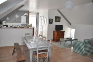 eine Küche und ein Wohnzimmer mit Tisch und Stühlen in der Unterkunft Les Hortensias in Gatteville-le-Phare