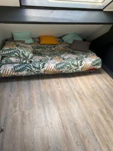 een bed in een kamer met een houten vloer bij Lodge de la Gare Vue Cathédrale in Rouen