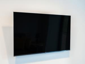 a flat screen tv hanging on a wall at Tyddyn Haidd in Amlwch