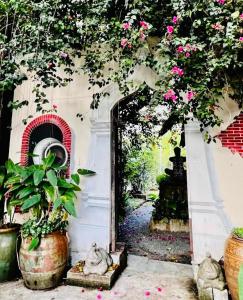 a doorway to a garden with pink flowers and plants at Artist's Place Trat in Trat