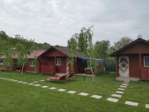 a group of cottages in a yard with a playground at Căsuțele Deltei in Mahmudia