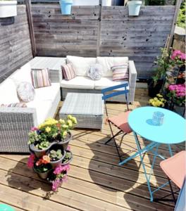 um pátio com um sofá e uma mesa e algumas plantas em Coup de Coeur sur le Port de ST GOUSTAN, Trés Beau T2 avec Terrasse em Auray