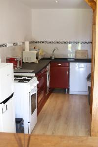 a kitchen with a white stove and a white refrigerator at L'Atelier @ Le Prielle in Madiran
