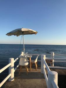 a table and chairs with an umbrella on the beach at Hotel Le Najadi in Santa Marinella