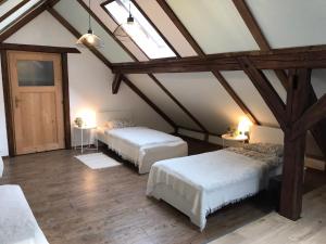 a attic room with two beds and two tables at Jutta Deluxe Farmhouse in Zwettl Stadt