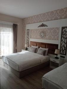 a bedroom with two beds and a clock on the wall at Alaçatı The Design Hotel in Alaçatı