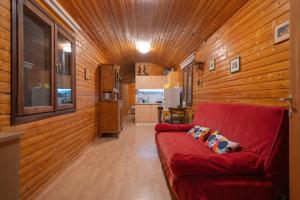 a red couch in a room with wooden walls at Train in the Forest in Aridaia