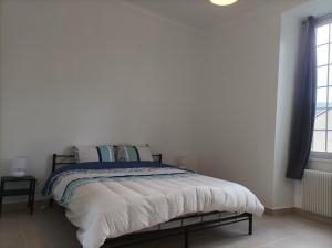 薩蘭萊班的住宿－O'Couvent - Appartement 73 m2 - 2 chambres - A311，一间卧室配有一张带白色床单的床和一扇窗户。