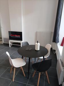 a dining room with a black table and chairs at O'Couvent - Appartement 73 m2 - 2 chambres - A311 in Salins-les-Bains